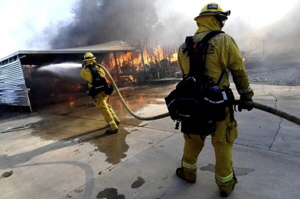 Firefighters try to protect surrounding homes as they battle the Sandalwood Fire in the Villa Calimesa Mobile Home Park in Calimesa, Calif., on Oct. 10, 2019. (Jennifer Cappuccio Maher/The Orange County Register/SCNG via AP)