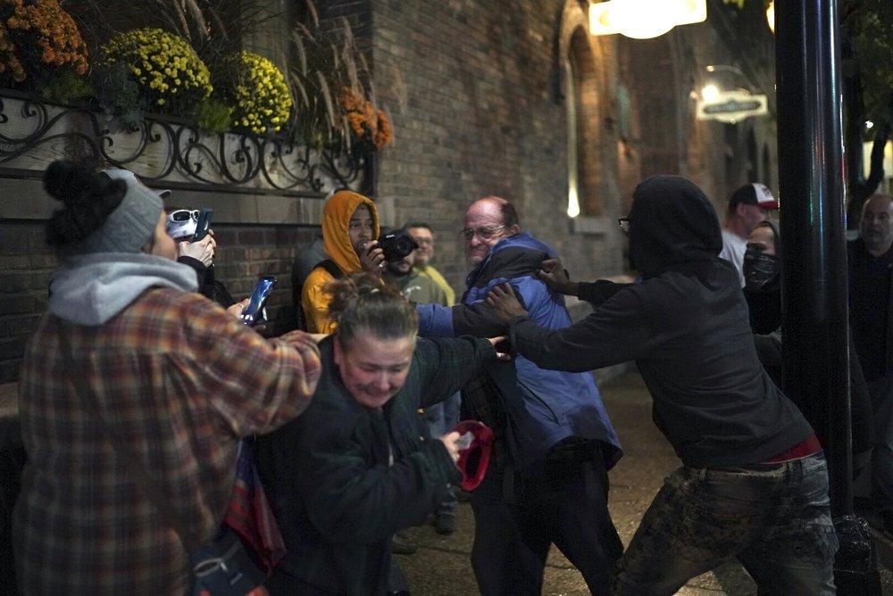 A Trump supporter is seen in a scuffle with a protester after his hat was grabbed off his head outside the Target Center after President Donald Trump visited Minneapolis, for a campaign rally on Oct. 10, 2019. (Renee Jones Schneider/Star Tribune via AP)