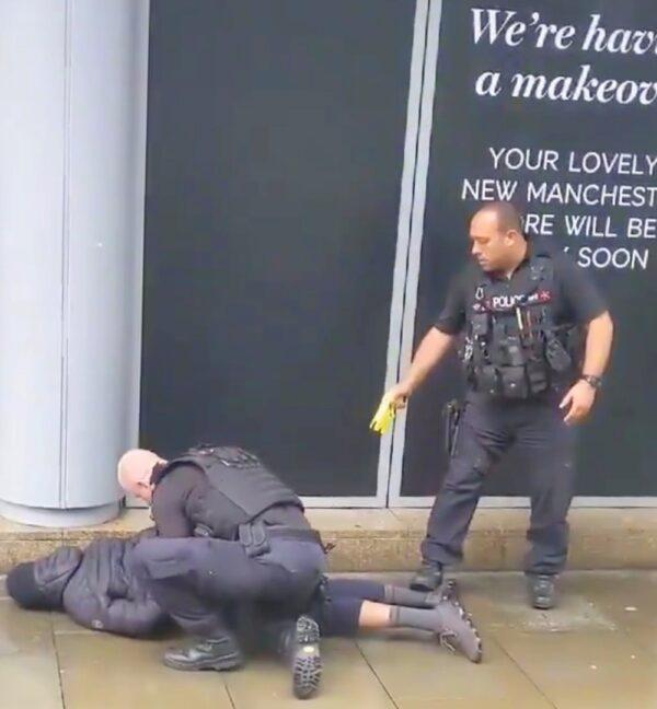 A police officer points a taser while the other holds a man down outside Arndale shopping center, where several people have been stabbed, in Manchester, Britain on Oct. 11, 2019 in this still image taken from a social media video. (John Greenhalgh via Reuters)