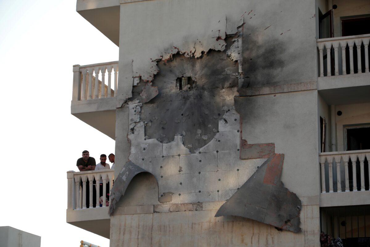 People look out from an apartment building which was damaged by a rocket fired from Syria, in Nusaybin, Turkey, on Oct. 10, 2019. (Sertac Kayar/Reuters)