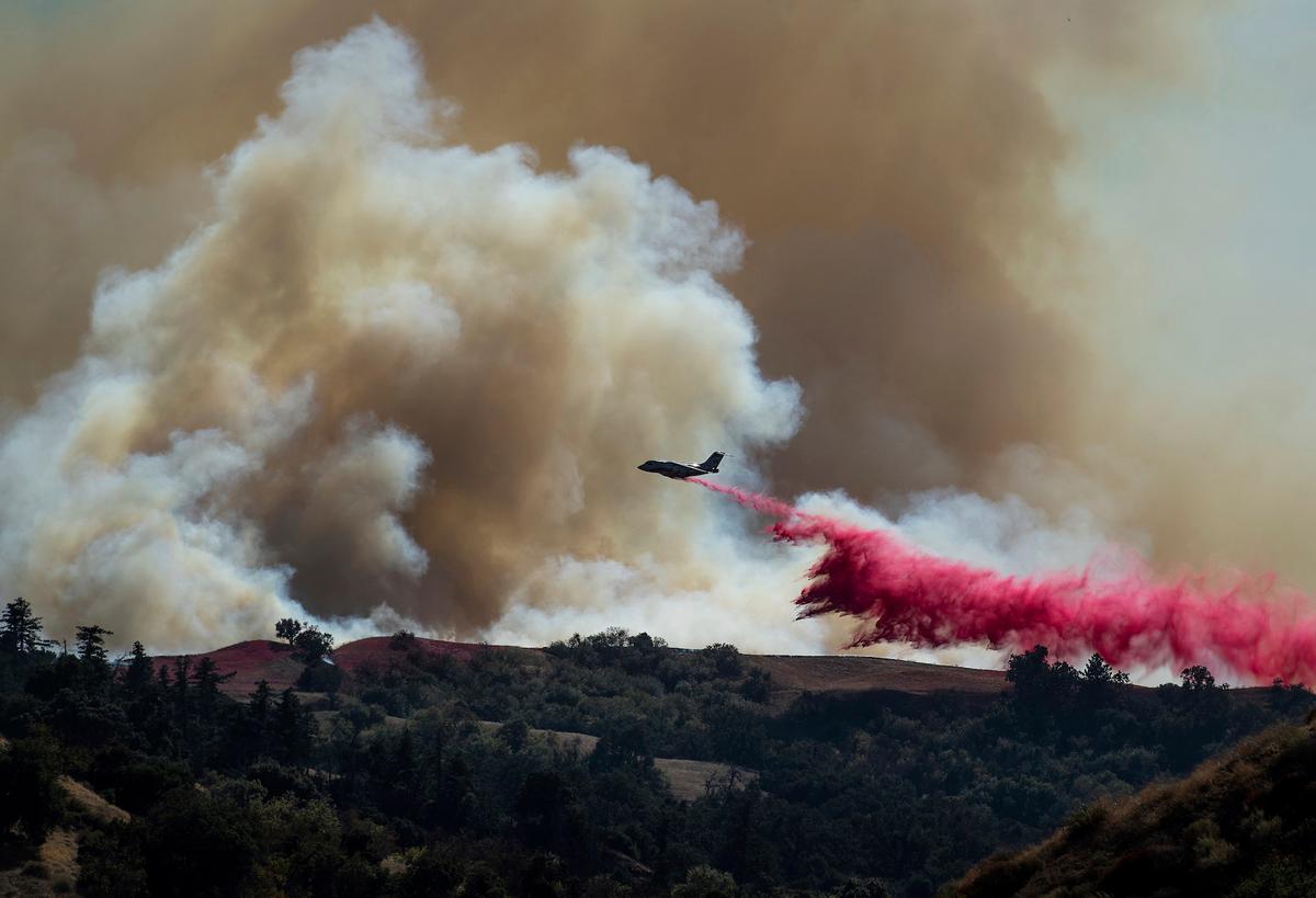 A tanker drops retardant on the Saddleridge Fire burning in Newhall, California, on Friday, Oct. 11, 2019. (AP Photo/Noah Berger)