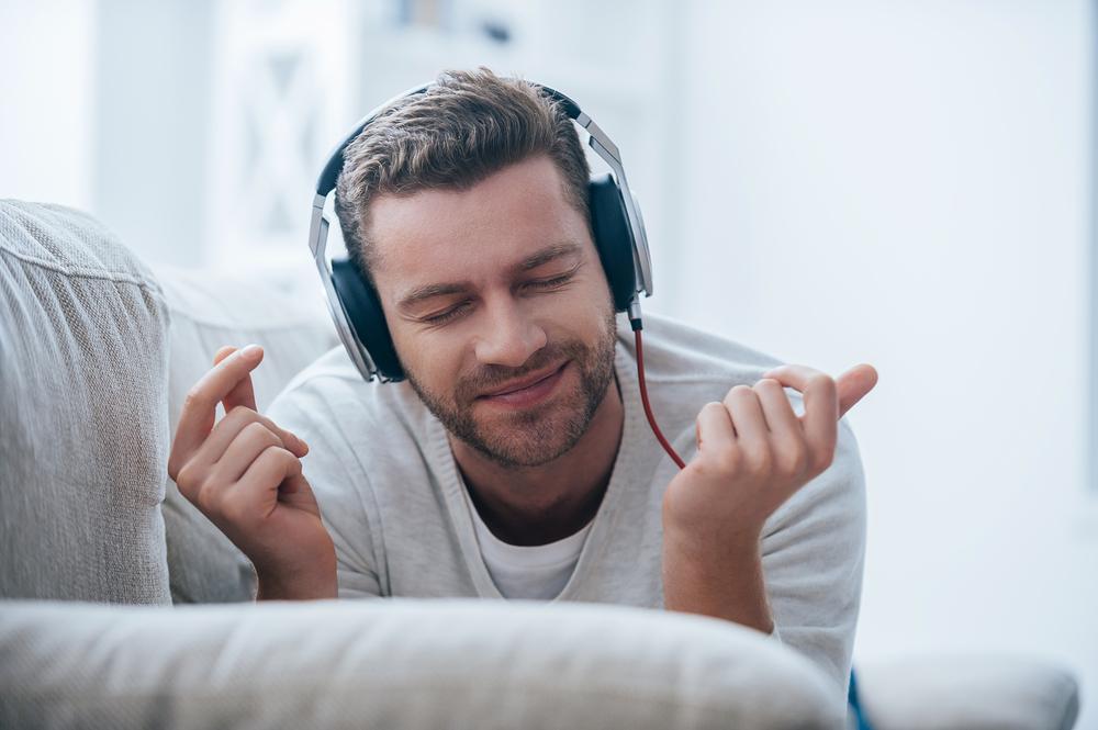 Illustration - Shutterstock | <a href="https://www.shutterstock.com/image-photo/enjoying-his-favorite-music-cheerful-young-340149857">G-Stock Studio</a>