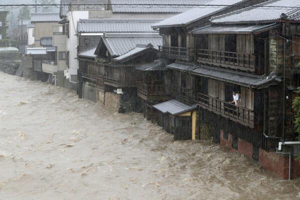 Men watch the swollen Isuzu River due to heavy rain caused by Typhoon Hagibis in Ise, central Japan, in this photo taken by Kyodo on Oct. 12, 2019. (Courtesy of Kyodo/via Reuters)