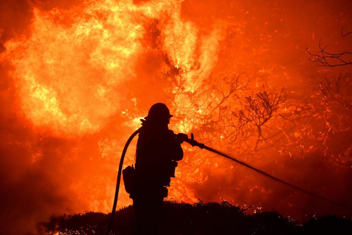 The Saddleridge fire flares up near a firefighter in Sylmar, California on Oct. 10, 2019. (AP Photo/Michael Owen Baker)
