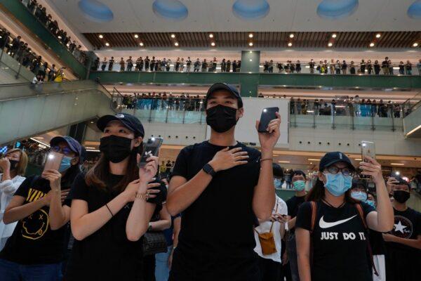 Protestors wearing masks in defiance of a recently imposed ban on face coverings sing "Glory to Hong Kong" at a shopping mall in Hong Kong, on Oct.13, 2019. (Vincent Yu/AP Photo)
