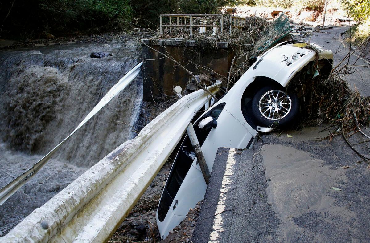 A vehicle falls off collapsed road in the typhoon-hit Kakuda city, Miyagi prefecture, northern Japan, on Oct. 13, 2019. (Kyodo News via AP)