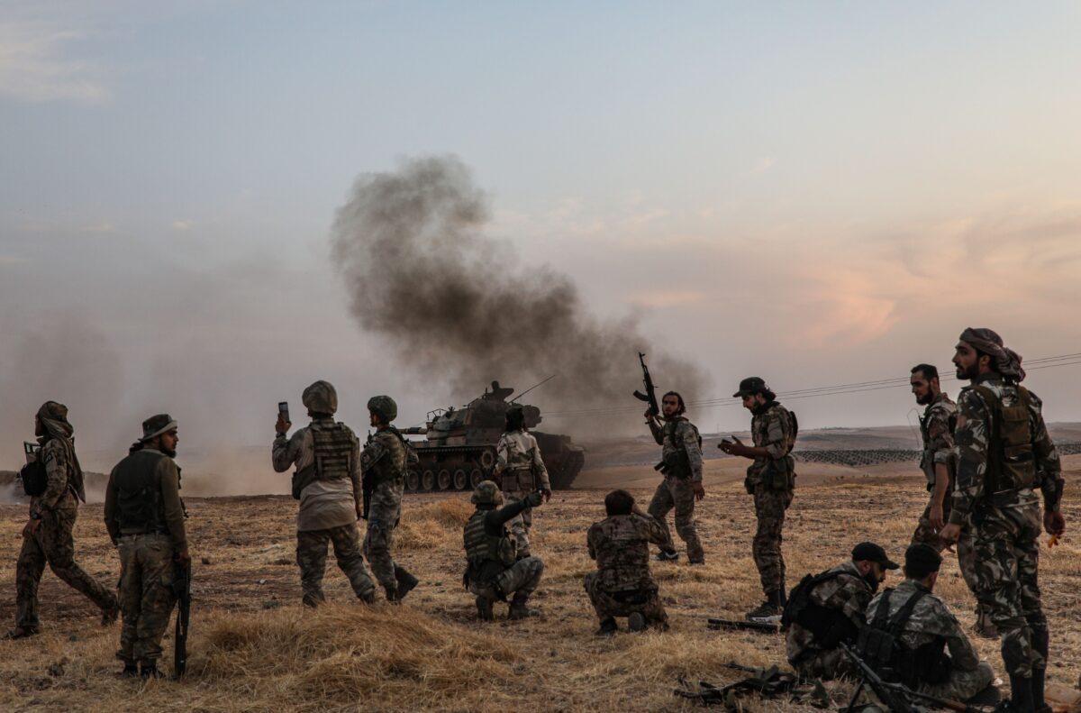 Turkish soldiers and Turkey-backed Syrian fighters gather on the northern outskirts of the Syrian city of Manbij near the Turkish border on Oct. 14, 2019, as Turkey and its allies continue their assault on Kurdish-held border towns in northeastern Syria. (Zein Al Rifai/AFP via Getty Images)