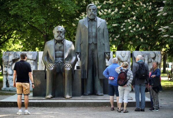 Visitors look at a statue of philosophers Karl Marx (L) and Friedrich Engels in a public park on May 4, 2018, in Berlin, Germany. (Sean Gallup/Getty Images)