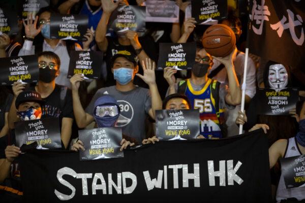 Demonstrators hold up signs in support of Houston Rockets general manager Daryl Morey during a rally at the Southorn Playground in Hong Kong, on Oct. 15, 2019. (AP Photo/Mark Schiefelbein)
