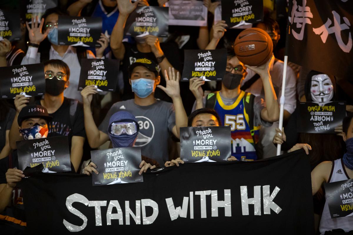 Demonstrators hold up signs in support of Houston Rockets general manager Daryl Morey during a rally at the Southorn Playground in Hong Kong, on Oct. 15, 2019. (AP Photo/Mark Schiefelbein)