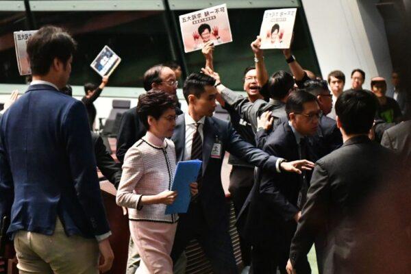 Hong Kong leader Carrie Lam (2nd L) leaves the chamber for a second time while trying to give her annual policy address as she is heckled by pro-democracy lawmakers at the Legislative Council (Legco) in Hong Kong on Oct. 16, 2019. (Anthony Wallace/AFP via Getty Images)
