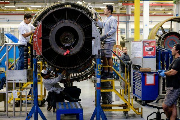 Men work with a jet engine at a General Electric aviation engine overhaul facility in Petropolis, Rio de Janeiro, Brazil on June 8, 2016. (Yasuyoshi Chiba/AFP/Getty Images)