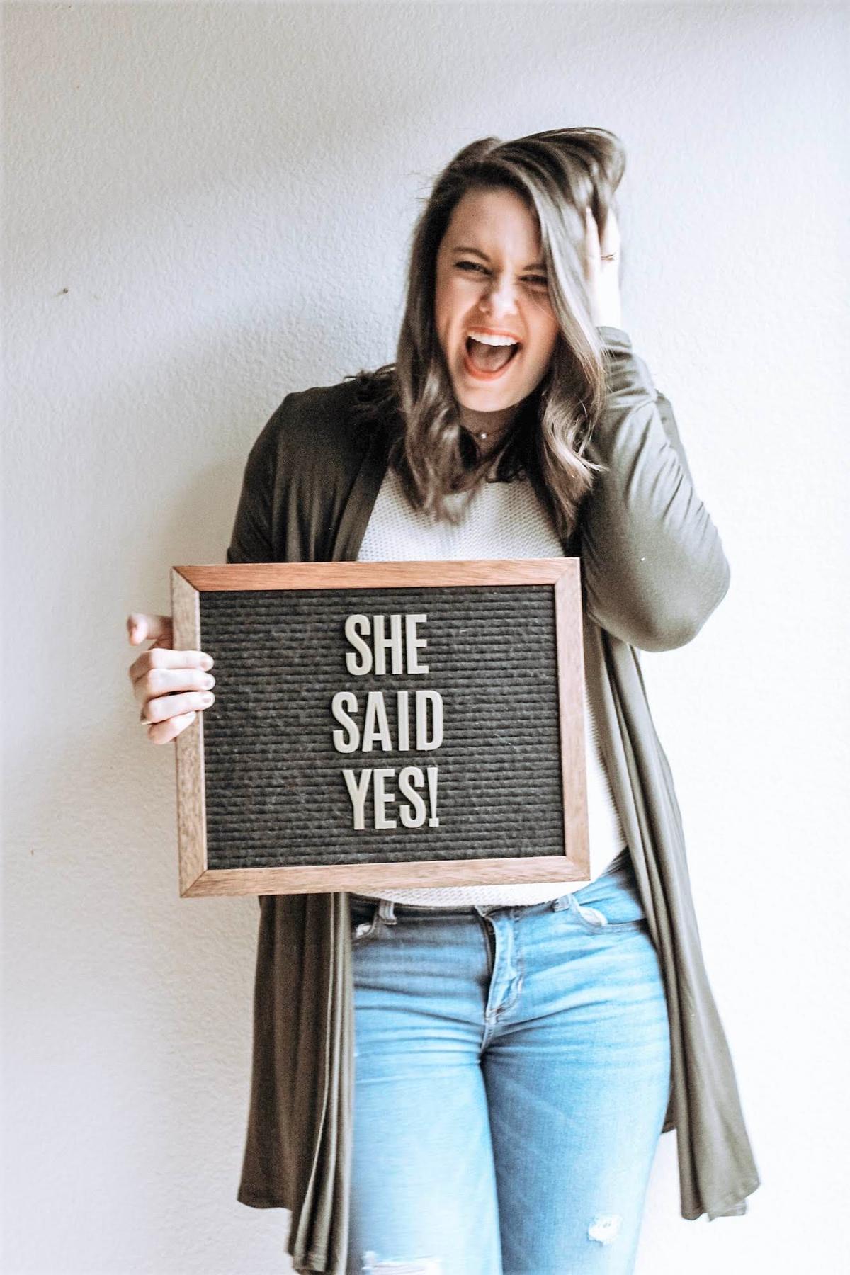 Taryn holding a sign reading "She Said Yes" at her sister-in-law's house in January 2019 after accepting a job at a preschool for children with special needs. (Photo courtesy of Taryn Logan)