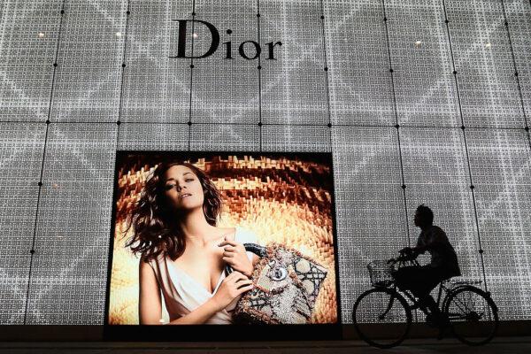 A Chinese man rides a bicycle past an advertisement for the Christian Dior store in Beijing on June 8, 2012. (Feng Li/Getty Images)