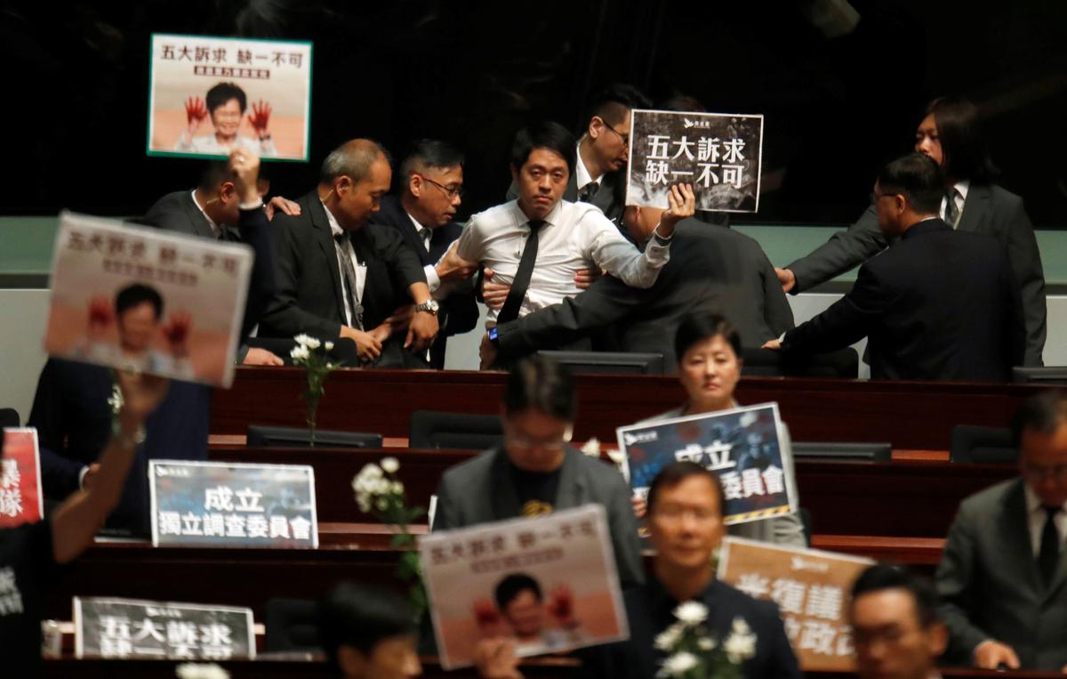 A pro-democracy lawmaker is escorted by security from the Legislative Council, as Hong Kong's Chief Executive Carrie Lam takes questions from lawmakers regarding her policy address, in Hong Kong, China on Oct. 17, 2019. (Umit Bektas/Reuters)