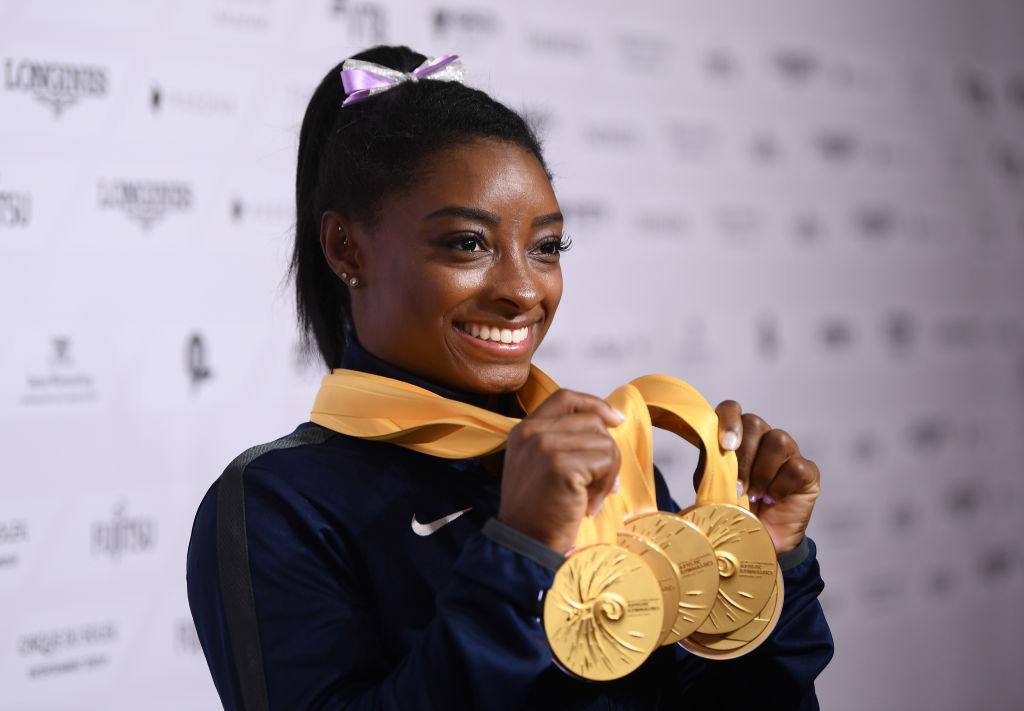 Biles of the USA poses with her medal haul at the FIG Artistic Gymnastics World Championships at Hanns Martin Schleyer Hall in Stuttgart, Germany. (©Getty Images | <a href="https://www.gettyimages.com.au/detail/news-photo/simone-biles-of-usa-poses-with-her-medal-haul-after-the-news-photo/1180820893">Laurence Griffiths</a>)