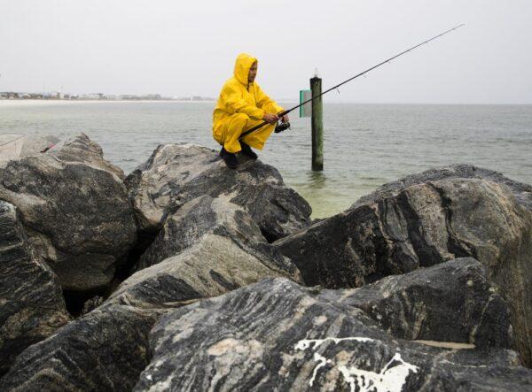 Michael Foster fishes as Tropical Storm Nestor approaches, in Mexico Beach, Fla.on Oct. 18, 2019. (Joshua Boucher/News Herald via AP)