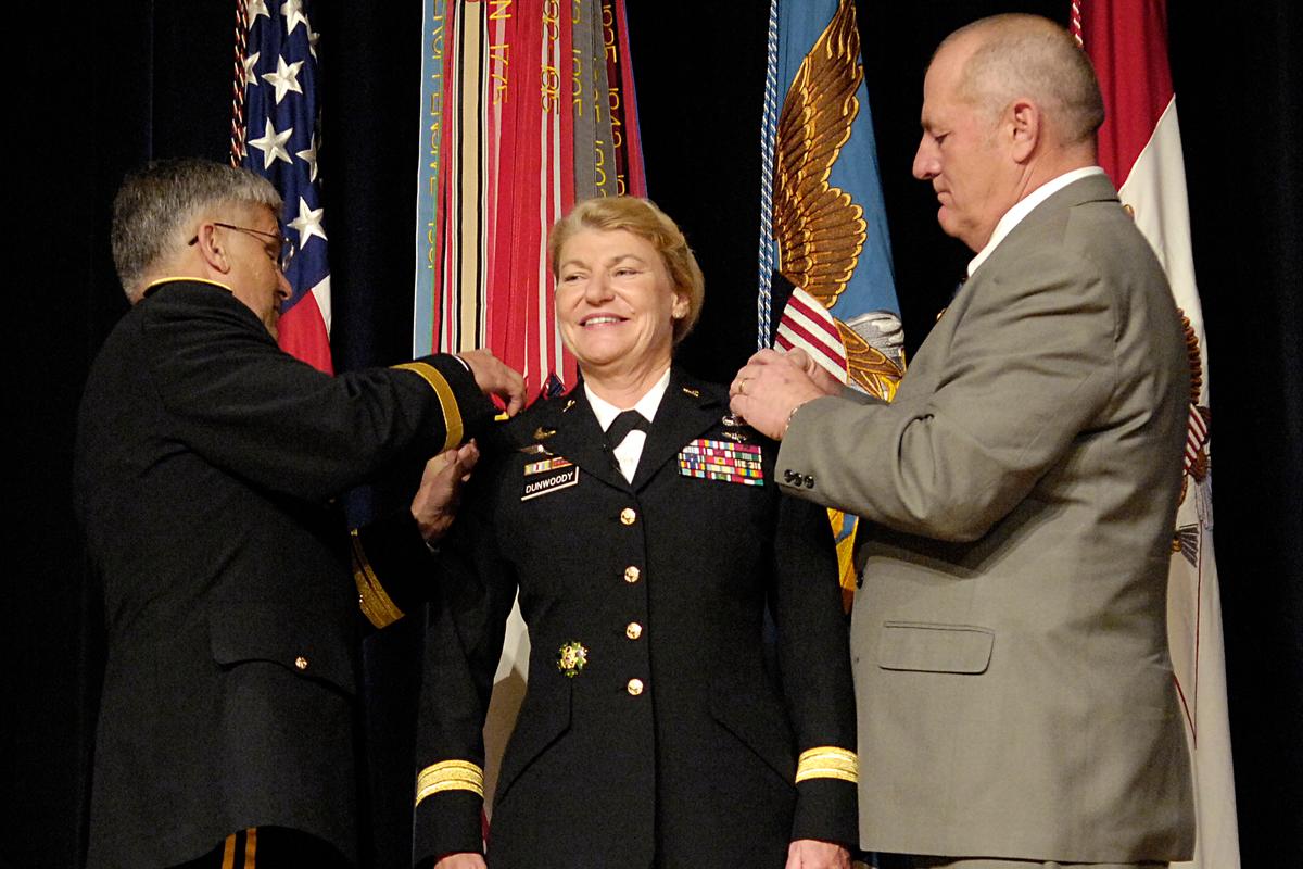 Dunwoody's 4th star pinning by Chief of Staff General George W. Casey (L) and her husband, Craig Brotchie, (R) at the Pentagon, 2008 (©Wikimedia Commons | <a href="https://commons.wikimedia.org/wiki/File:Dunwoody_GenAnn_4stars_081114-N-2855B-170.jpg">Defense Department photo/Petty Officer 2nd Class Molly A. Burgess</a>)