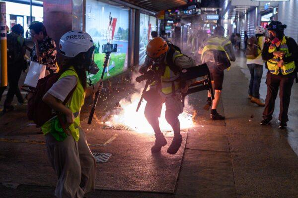 Journalists react as police fire tear gas from Causeway Bay MTR station during clashes with pro-democracy demonstrators in Hong Kong on Sept. 8, 2019. (Philip Fong/AFP/Getty Images)