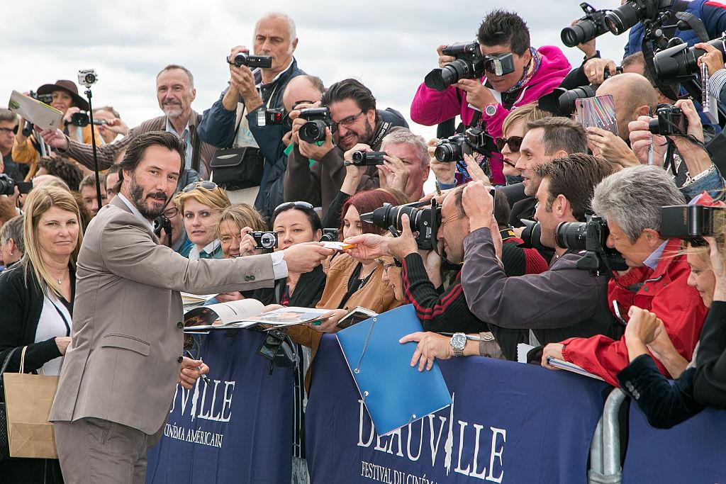 Actor Keanu Reeves signs autographs after posing next to the beach closet dedicated to him during a photocall on Sept. 4, 2015. (©Getty Images | <a href="https://www.gettyimages.com/detail/news-photo/actor-keanu-reeves-signs-autographs-after-posing-next-to-news-photo/486471450?adppopup=true">Marc Piasecki</a>)
