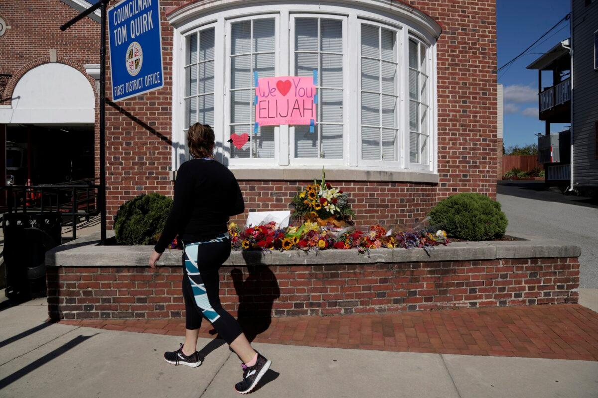 A woman looks at flowers and messages outside of the office of the late Rep. Elijah Cummings (D-Md.) a day after the congressman died Oct. 18, 2019, in Catonsville, Md. (AP Photo/Julio Cortez)