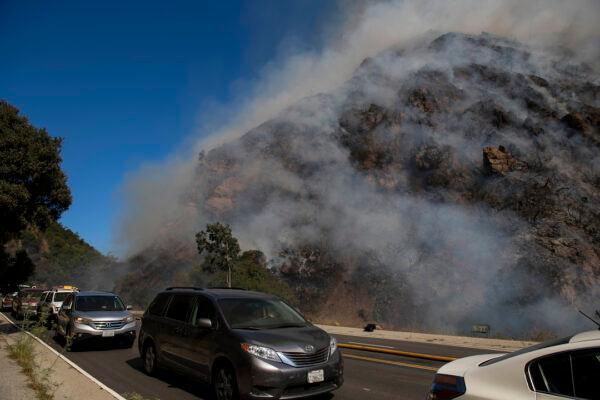 Palisades residents flee the area as a wildfire erupts in the Pacific Palisades area of Los Angeles, on Oct. 21, 2019. (Christian Monterrosa/AP Photo)