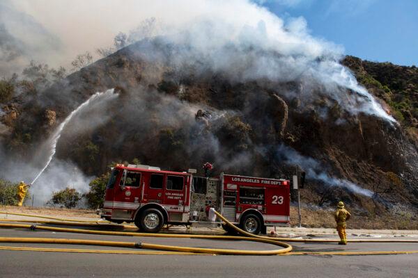 Firefighters begin hosing down the flames of the Palisades Fire minutes after it ignites in the Pacific Palisades, section of Los Angeles on Oct. 21, 2019. (Christian Monterrosa/AP Photo)