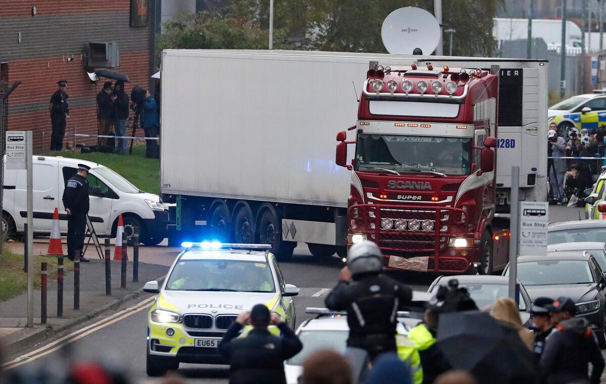 Police escort the truck that was found to contain a large number of dead bodies as they move it from an industrial estate in Thurrock, south England, on Oct. 23, 2019. (Alastair Grant/AP)