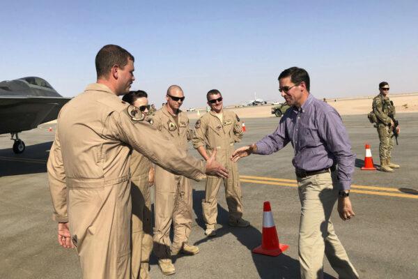 Defense Secretary Mark Esper talks with U.S. troops in front of an F-22 fighter jet deployed to Prince Sultan Air Base in Saudi Arabia, Tuesday, Oct. 22, 2019. (Lolita Baldor/AP Photo)