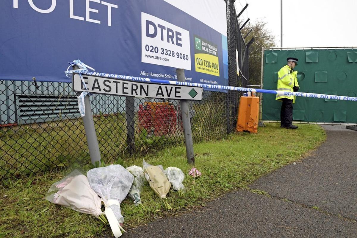 Floral tributes at the Waterglade Industrial Park in Thurrock, Essex, England on Oct. 24, 2019 the day after 39 bodies were found inside a truck on the industrial estate. British media are reporting that the 39 people found dead in the back of a truck in southeastern England were Chinese citizens. (Stefan Rousseau, PA via AP)