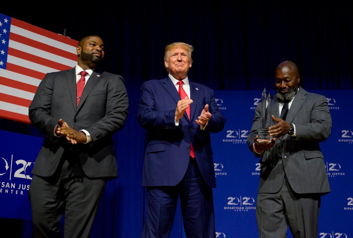President Donald Trump (C) is awarded the Bipartisan Justice Award by Matthew Charles (R), who was released from federal prison through the First Step Act, prior to delivering remarks at the 2019 Second Step Presidential Justice Forum in Columbia, South Carolina on Oct. 25, 2019. (Jim Watson/AFP via Getty Images)