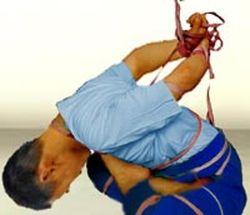 Reenactment of the "tying up in lotus" torture. (Minghui.org)