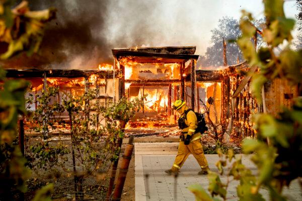Woodbridge firefighter Joe Zurilgen passes a burning home as the Kincade Fire rages in Healdsburg, Calif., on Oct 27, 2019. (Noah Berger/AP Photo)