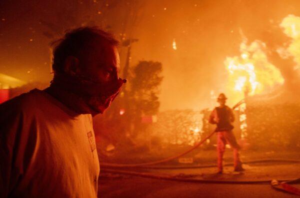 A man walks past a burning home during the Getty fire on Oct. 28, 2019, in Los Angeles, Calif. (Christian Monterrosa/AP Photo)