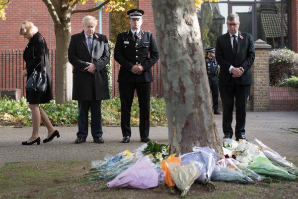Prime Minister Boris Johnson stands with the Chief Constable of Essex Police, Ben-Julian Harrington, after laying flowers during a visit to Thurrock Council Offices in Grays, England on Oct. 28, 2019. (Stefan Rousseau-WPA Pool/Getty Images)