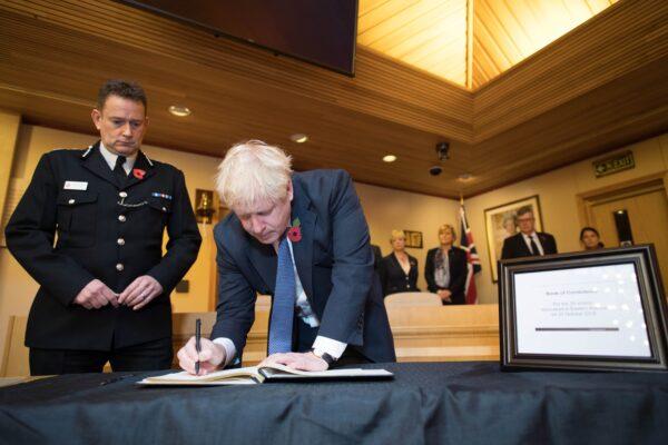 Britain's Prime Minister Boris Johnson signs a book of condolence during a visit to Thurrock Council Offices in Thurrock, east of London on Oct. 28, 2019. (Stefan Rousseau/POOL/AFP via Getty Images)