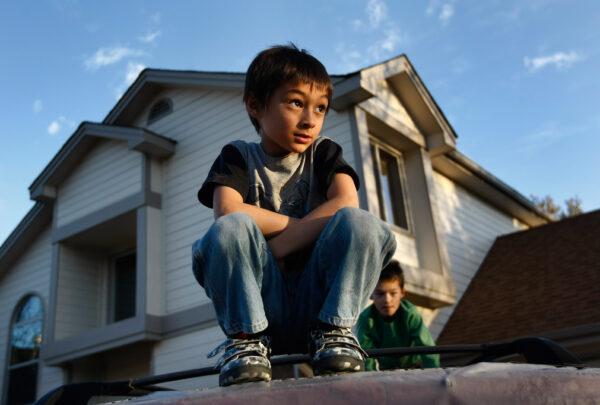 Falcon Heene (C), 6, is shown outside his home October 15, 2009 in Ft. Collins, Colorado. Falcon was found hiding in the attic of his family home after his siblings had erroneously reported that he was riding aboard an experimental balloon built by his father. Media helicopters, military aircraft and the FAA all assisted in tracking down the wayward balloon, which landed in a field in Weld County, Colorado. (Photo by John Moore/Getty Images)