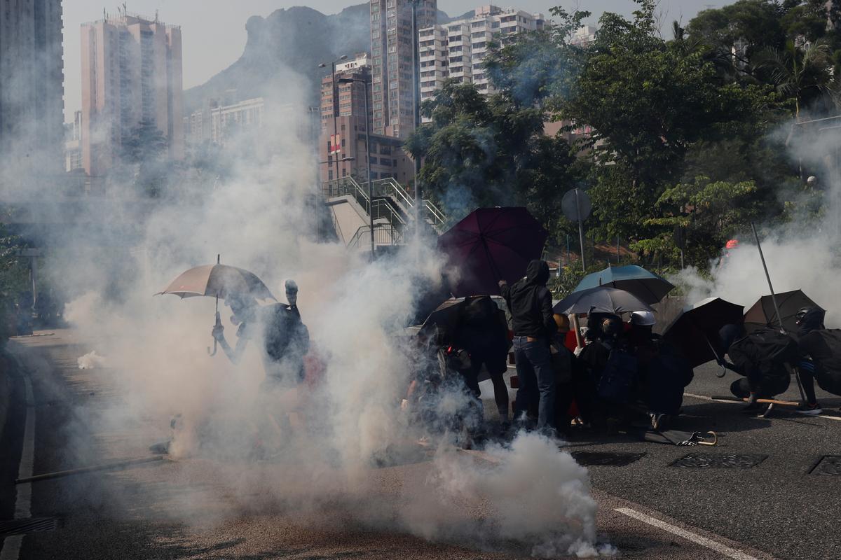 Anti-government protesters react to tear gas during a demonstration on China's National Day under Lion Rock mountain in the Wong Tai Sin neighborhood of Hong Kong on Oct. 1, 2019. (Tyrone Siu/Reuters)