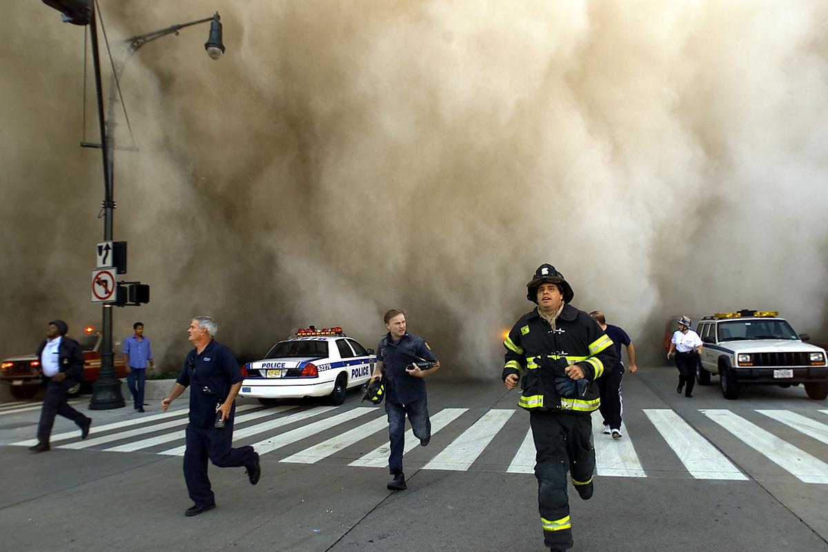 Policemen and firemen run away from the huge dust cloud caused as the World Trade Center's Tower One collapses after terrorists crashed two hijacked planes into the twin towers, Sept. 11, 2001, in New York City. (©Getty Images | <a href="https://www.gettyimages.com/detail/news-photo/policemen-and-firemen-run-away-from-the-huge-dust-cloud-news-photo/1161273?adppopup=true">Jose Jimenez/Primera Hora</a>)