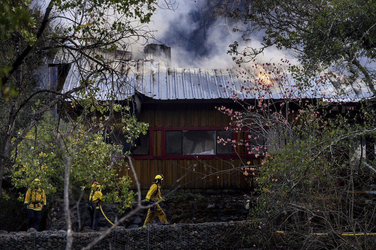 Firefighters pass a burning structure as the Kincade fire burns in Calistoga, Calif., on Oct. 29, 2019. (AP Photo/Noah Berger)