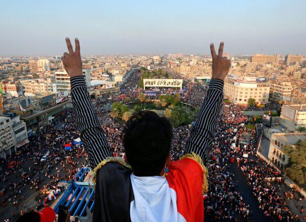 A protester gives the victory sign as thousands of anti-government protesters gather in Tahrir Square during ongoing demonstrations in Baghdad, Iraq, on Oct. 31, 2019. (AP Photo/Hadi Mizban)