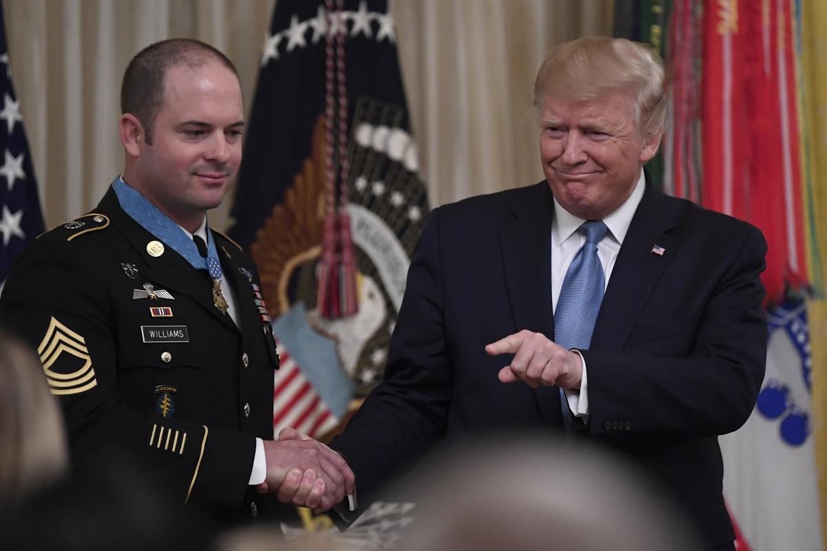 President Donald Trump, right, shakes hands with U.S. Army Master Sgt. Matthew Williams, left, currently assigned to the 3rd Special Forces Group, after presenting him with the Medal of Honor during a ceremony in the East Room of the White House in Washington on Oct. 30, 2019. (Susan Walsh/AP Photo)