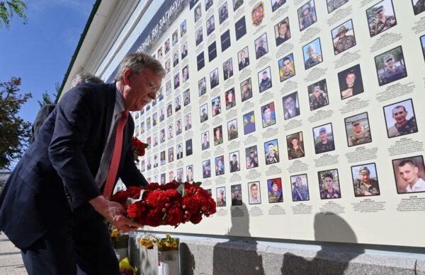 Former National Security Advisor John Bolton lays flowers at a memorial for those killed in the war with Russia-backed separatists in the Donbas region, Kyiv, Ukraine, on Aug. 27, 2019. (Sergei Supinski/AFP/Getty Images)