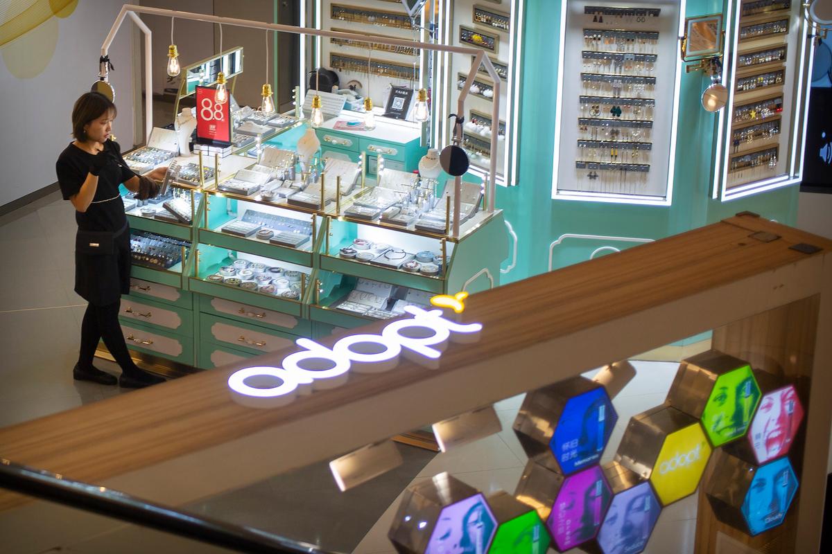 An employee dusts merchandise at a jewelry store in a shopping mall in Beijing on Oct. 31, 2019. (Mark Schiefelbein/AP)