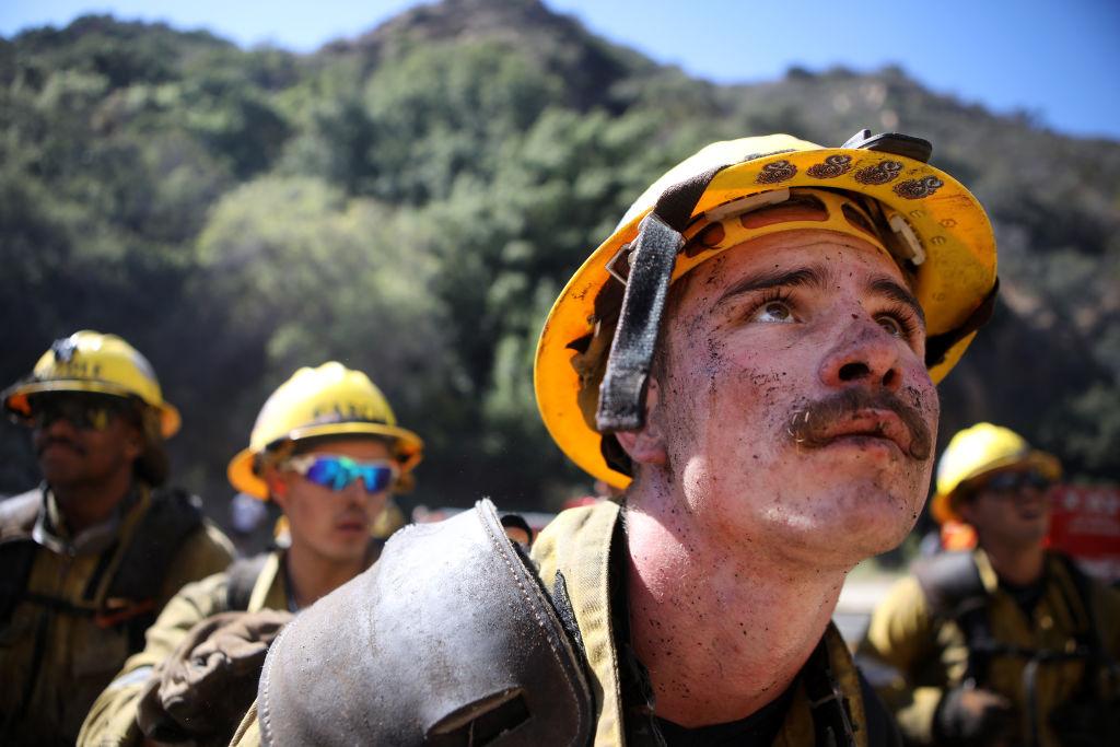 A Los Angeles County Fire Department firefighter looks up toward the Palisades Fire as it advances downhill on Oct. 21, 2019. (©Getty Images | <a href="https://www.gettyimages.com.au/detail/news-photo/los-angeles-county-fire-department-firefighter-looks-up-news-photo/1182560888">Mario Tama</a>)