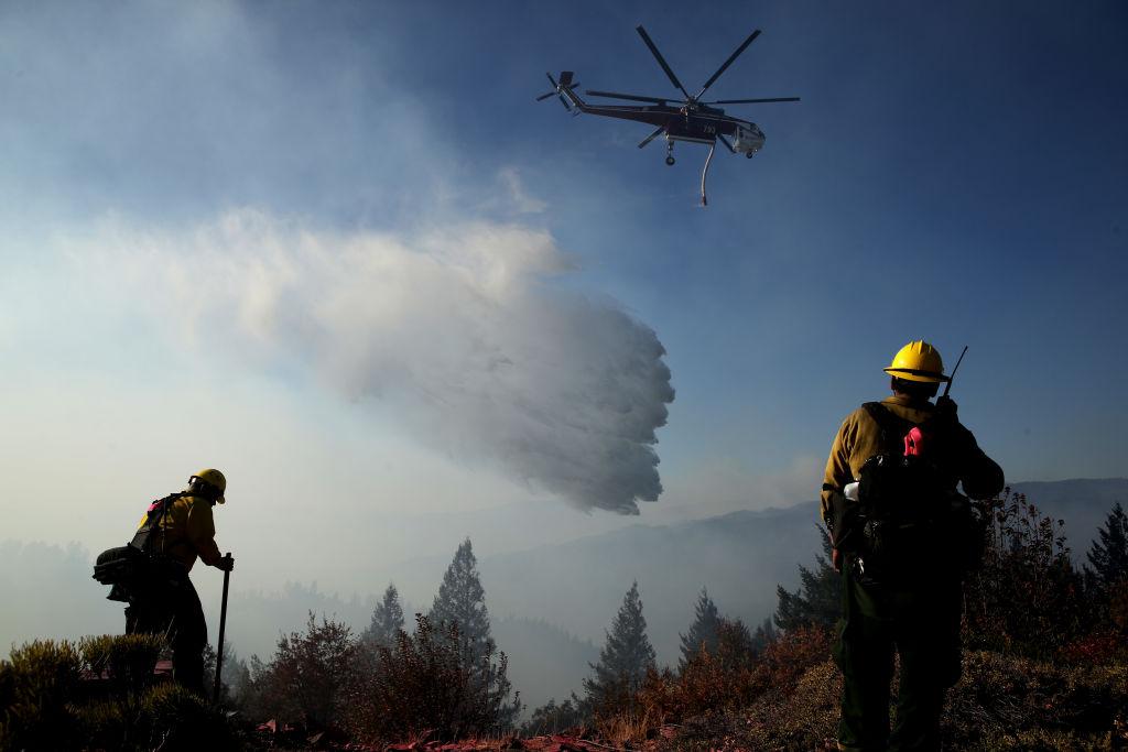 Firefighters stand in the yard of a home as they monitor air operations battling the Kincade Fire in Healdsburg on Oct. 29, 2019. (©Getty Images | <a href="https://www.gettyimages.com.au/detail/news-photo/firefighters-stand-in-the-yard-of-a-home-as-they-monitor-news-photo/1184265341">Justin Sullivan</a>)