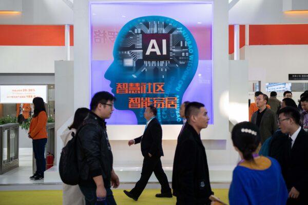 Visitors walk past a stand with AI security cameras using facial recognition technology at the 14th China International Exhibition on Public Safety and Security at the China International Exhibition Center in Beijing on Oct. 24, 2018. (Nicolas Asfouri/AFP via Getty Images)