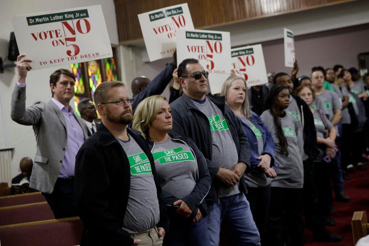 People wearing "Save The Paseo" shirts stand among attendees at a rally to keep a street named in honor of Dr. Martin Luther King Jr. at Paseo Baptist Church in Kansas City, Mo., on Nov. 3, 2019. (Charlie Riedel/AP Photo)