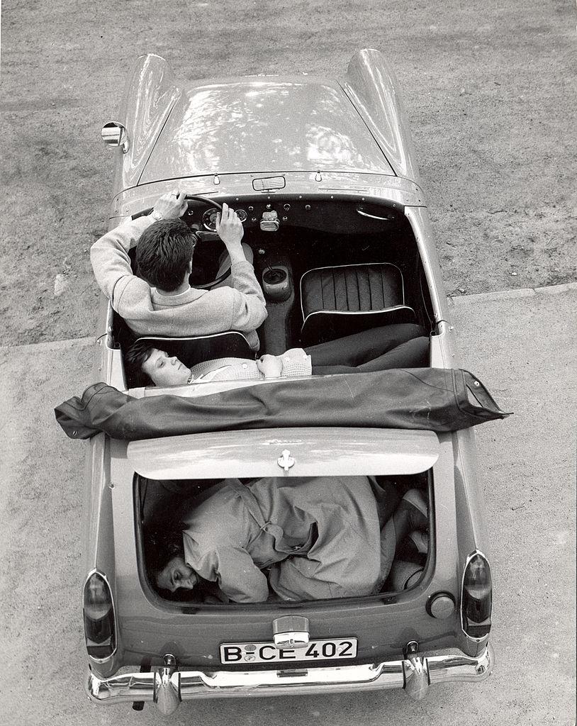 Heinz Meixner, with his fiancee and her mother, Frau Thurau, show how they arranged themselves in his Austin-Healey Sprite to drive through a checkpoint at the Berlin Wall, Germany, circa 1965. (Express Newspapers/Getty Images)