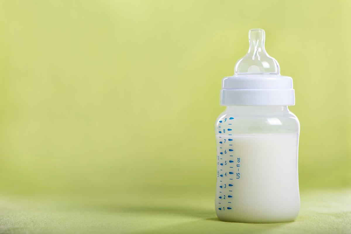 Illustration - Shutterstock | <a href="https://www.shutterstock.com/fr/image-photo/baby-milk-bottle-on-green-sheet-376761751">wsantina</a>